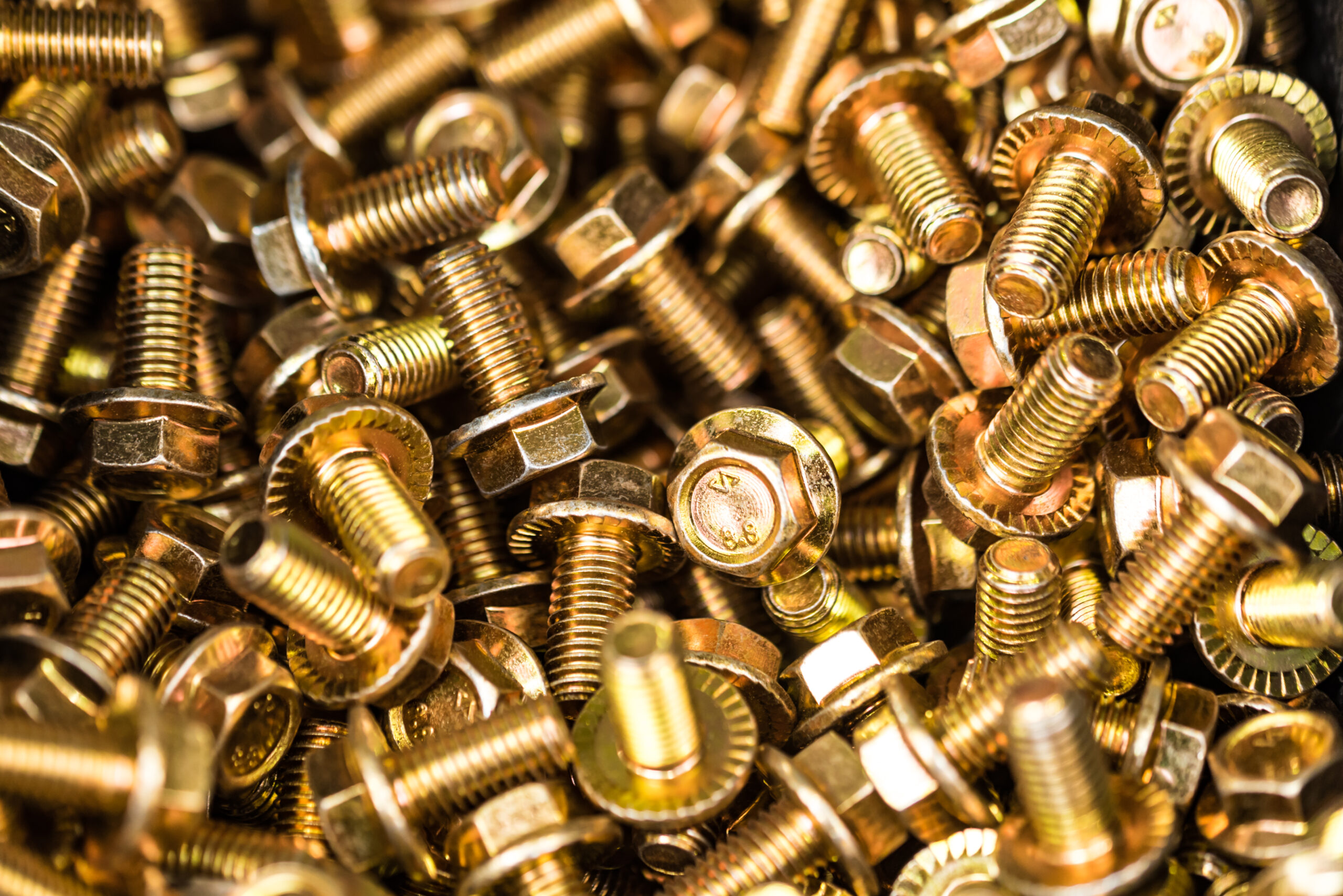 Close-up glossy brass bolts background. Brand new stainless screws or fastener. Industrail abstract concept